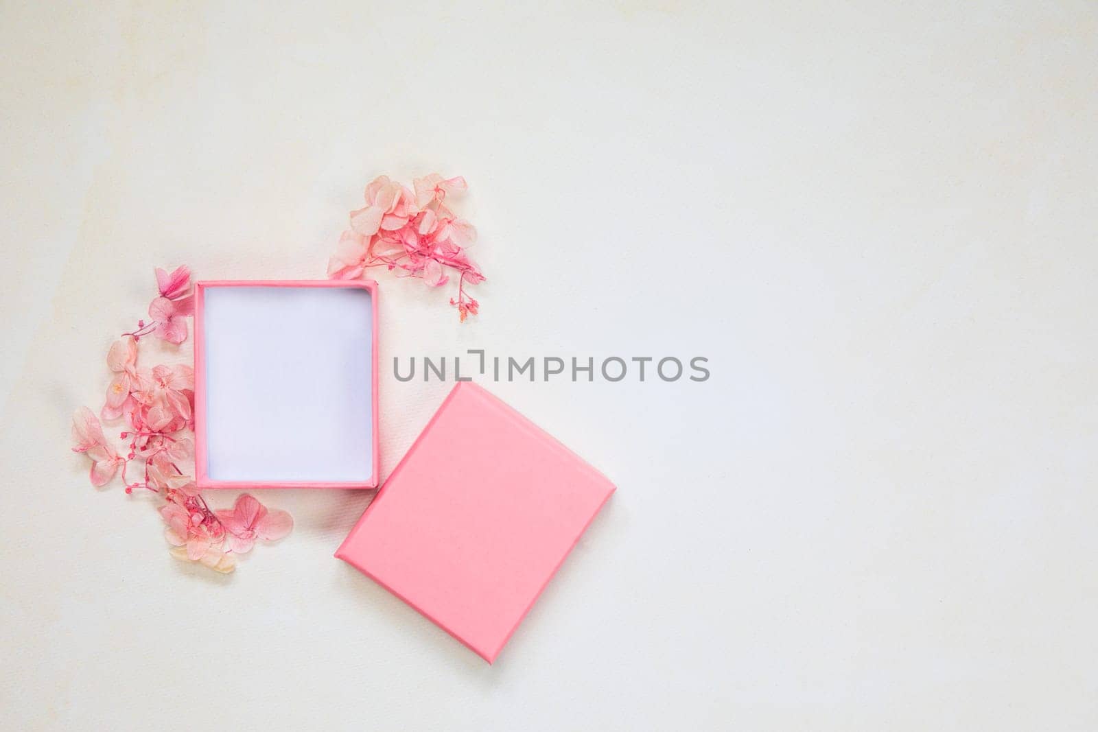Open and closed pink gift box place for product on bright background with flowers .Flat lay, top view, mock-up gift,present Mothers Day,Valentines Day, Birthday concept by Annebel146