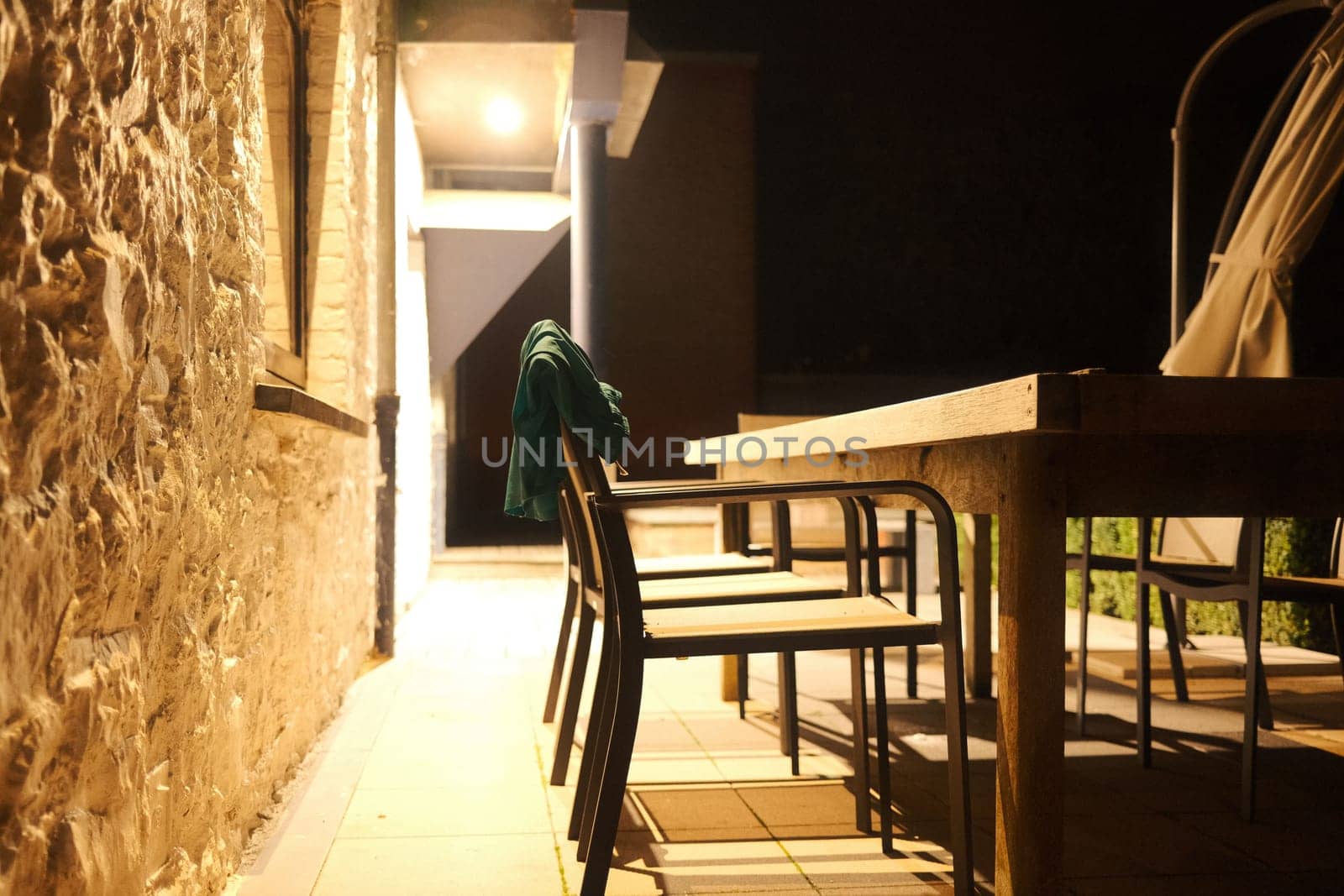 Wooden chair with swimming trunks over its back on a terrace in Burdinne, Belgium at night