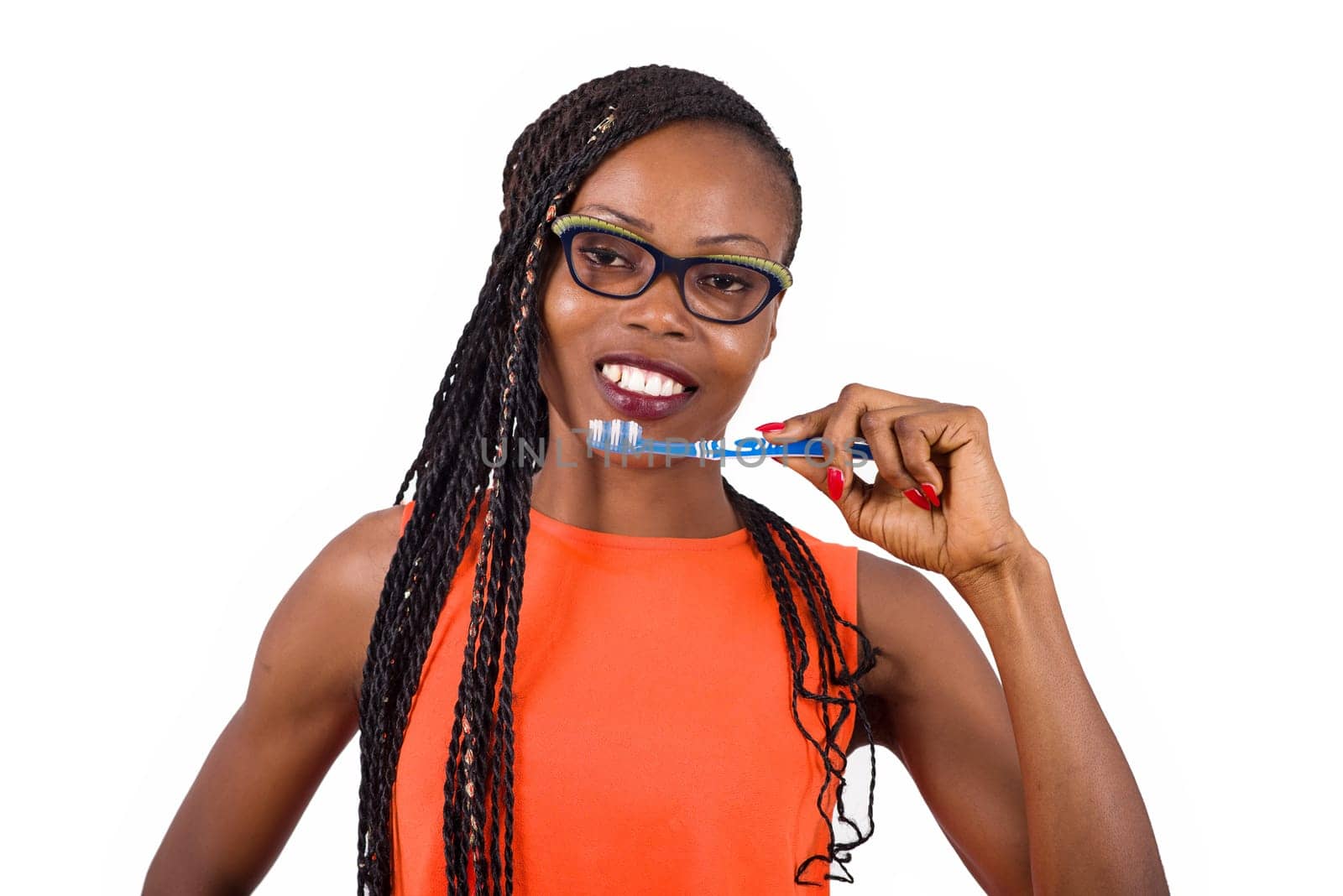 young girl standing in eyeglasses on background plan smiling to hold a toothbrush to the mouth.