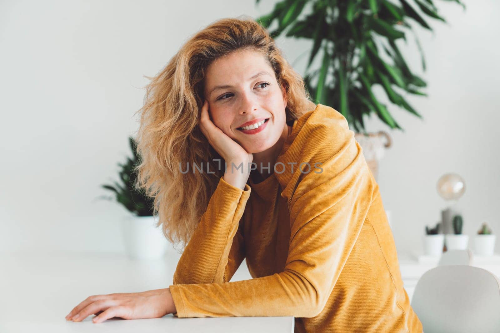 Cheerful happy caucasian woman relaxing at home on her day off work. Adult content woman spending time at home, in her apartment, resting on the couch, having a cup of coffee, feeling good.