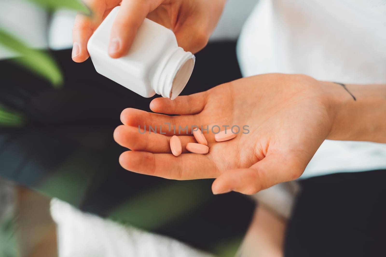 Supplements, four little pink pills on the palm of woman hand by VisualProductions