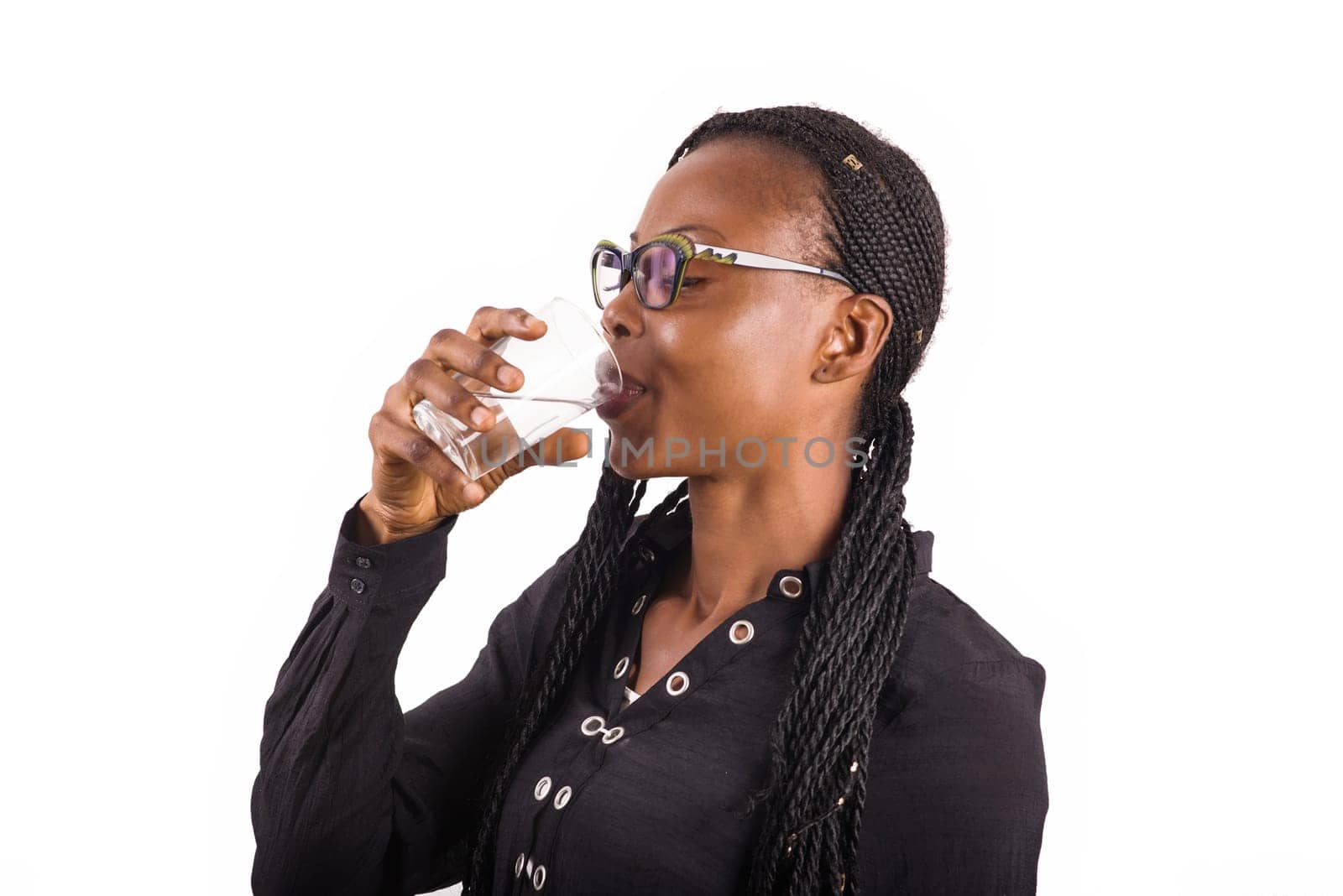 young woman standing on white background in glasses drink some water.