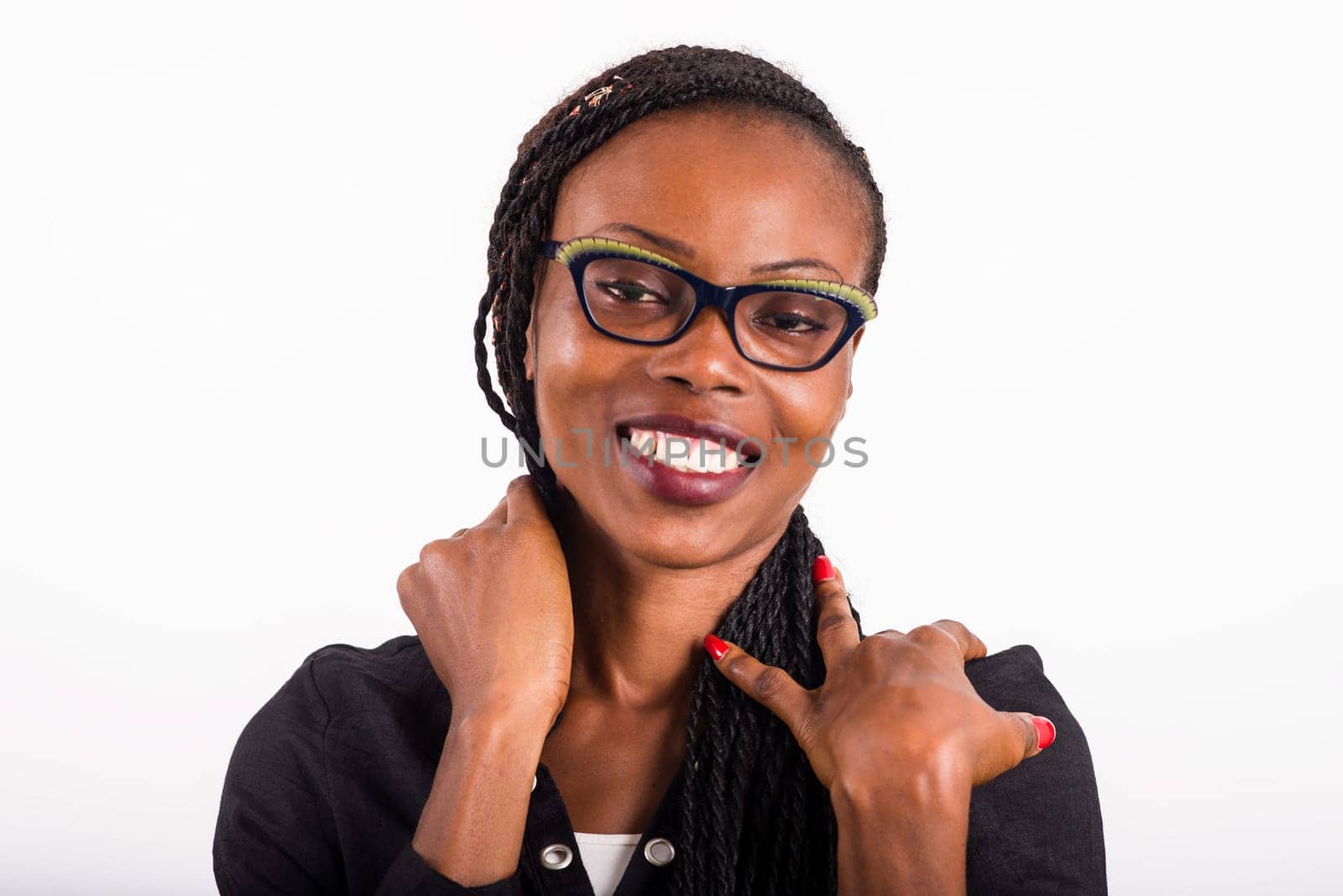 young woman standing on white background looking at camera smiling.