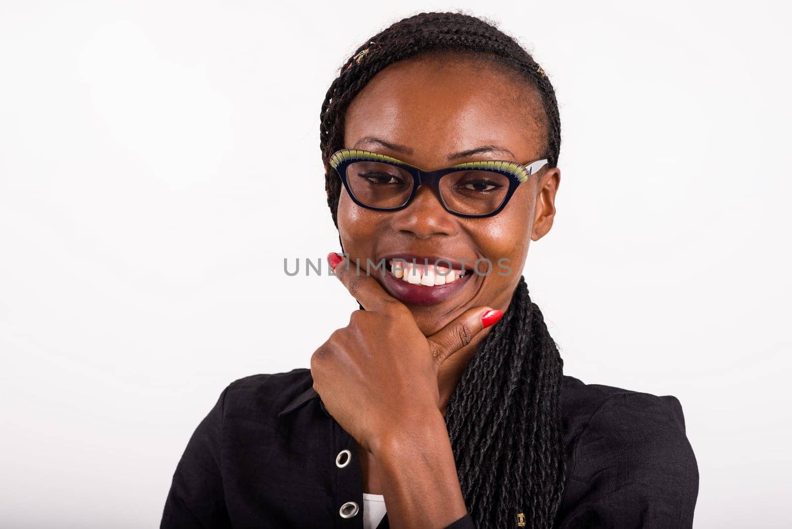 young african woman standing on white background looking at camera smiling.