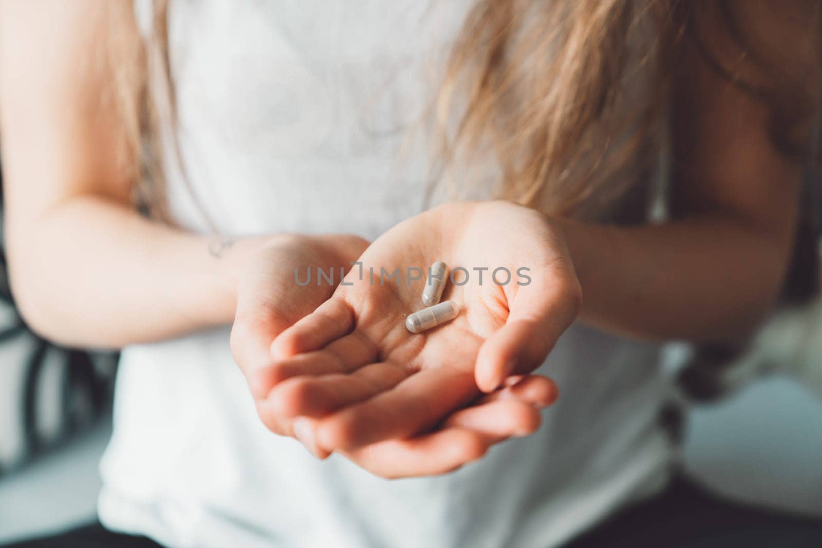 Close up two vitamin pills on the palm of unrecognizable woman hand by VisualProductions