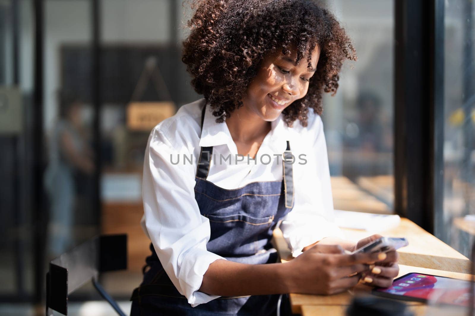 Startup successful small Beautiful American African owner sme with tablet in coffee shop restaurant, hands up in winner is gesture, Happy to be successful celebrating achievement success by Manastrong