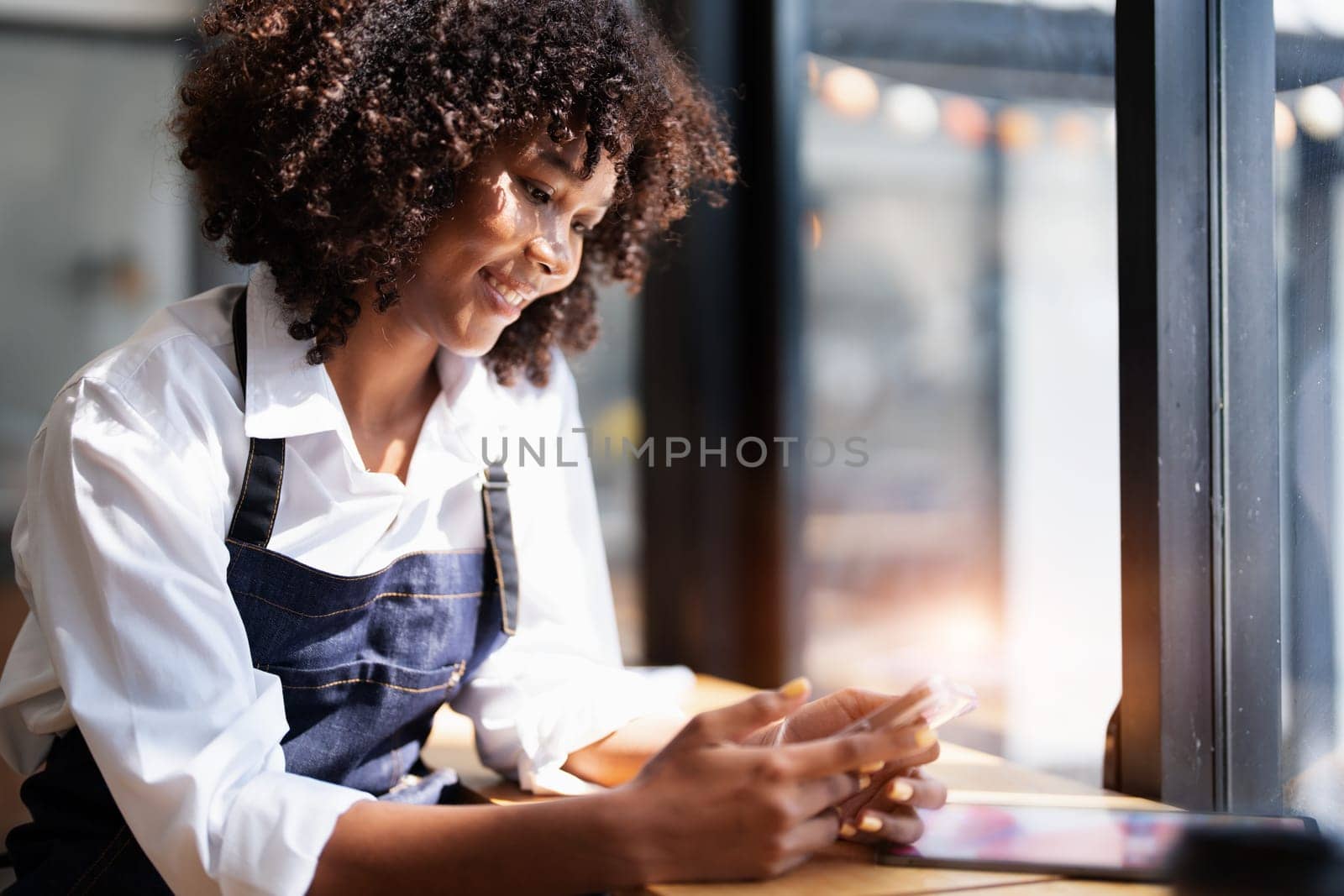 Startup successful small Beautiful American African owner sme with tablet in coffee shop restaurant, hands up in winner is gesture, Happy to be successful celebrating achievement success by Manastrong