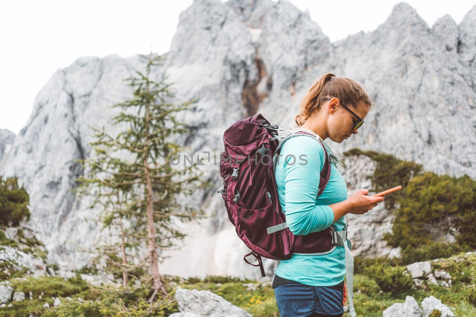 Caucasian woman hiking with Backpack on the Beautiful trail in European Alps early in the morning. Travel and Adventure Concept. High quality photo