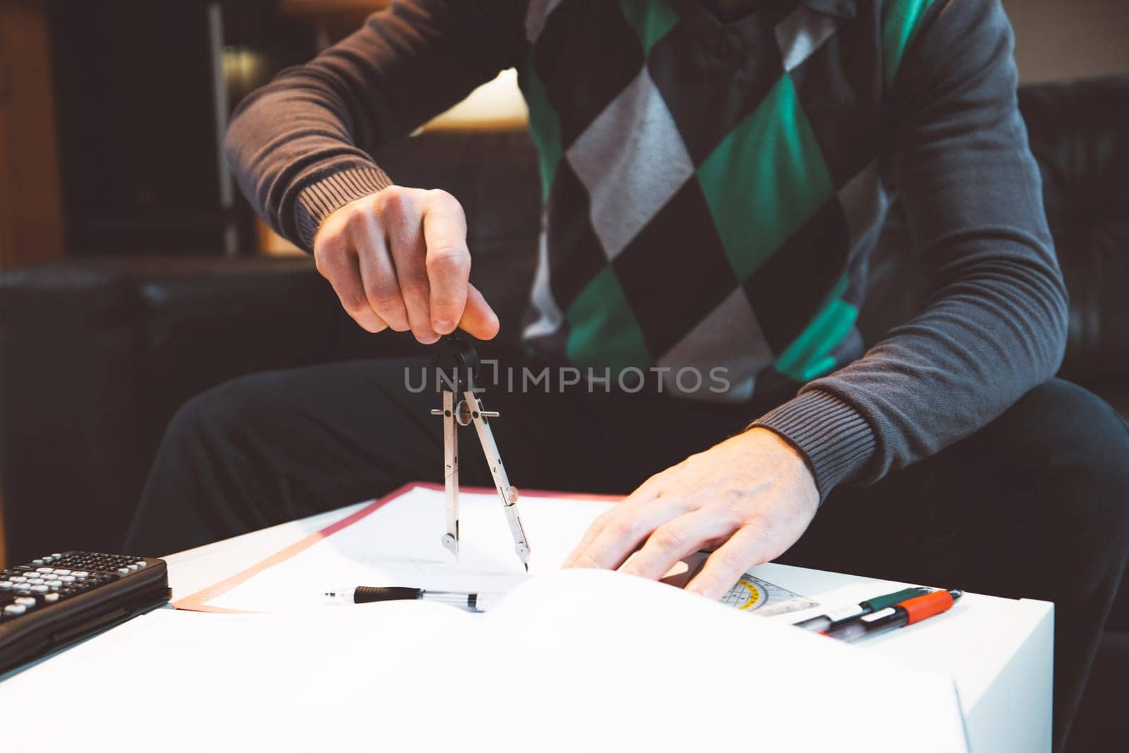 Unrecognizable man studying at home, doing exercises for math exam by VisualProductions