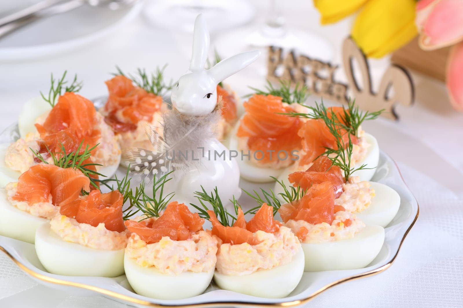 Appetizer of eggs stuffed salmon pate and yolks with salmon slices. Idea Easter table 