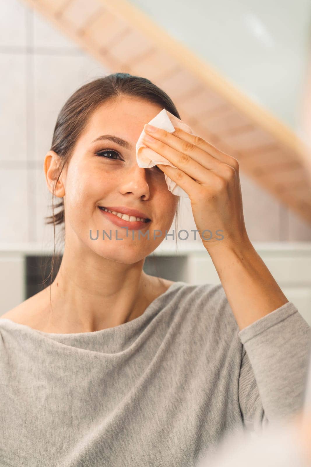 Beautiful young woman cleaning her face, removing make up with a cotton pad and micellar water. Skin care and beauty. Young beautiful woman cleaning her face. High quality photo