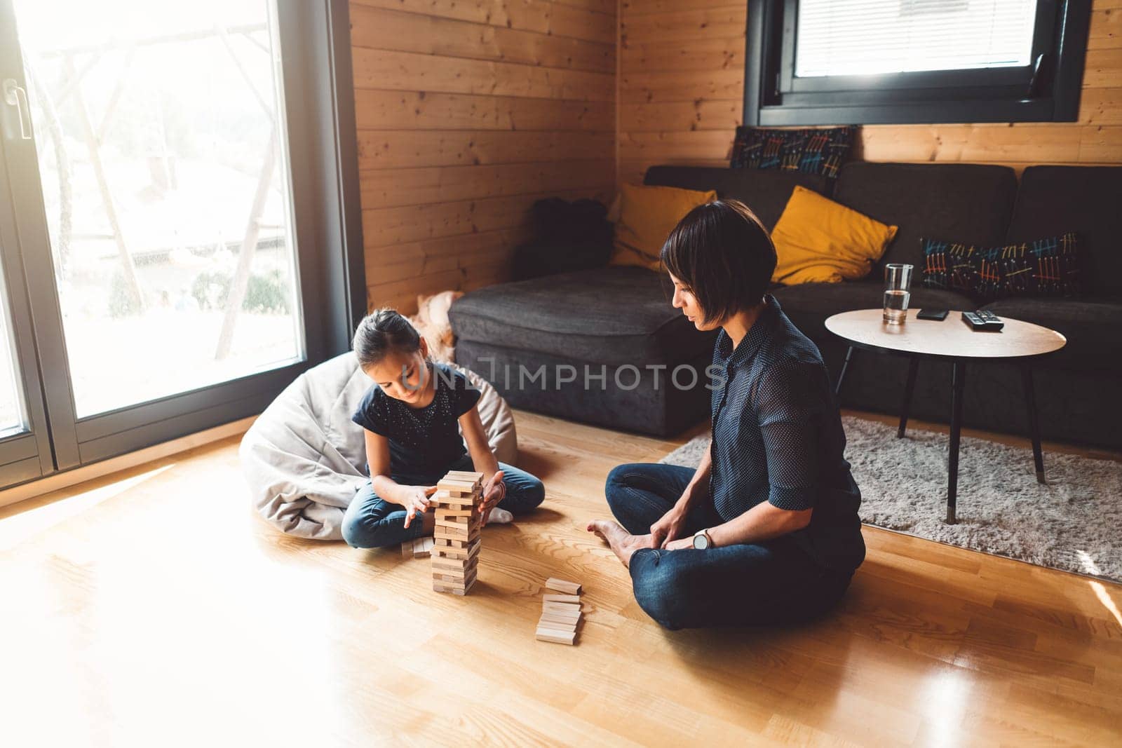Mom playing board games with her daughter in the living room at home by VisualProductions