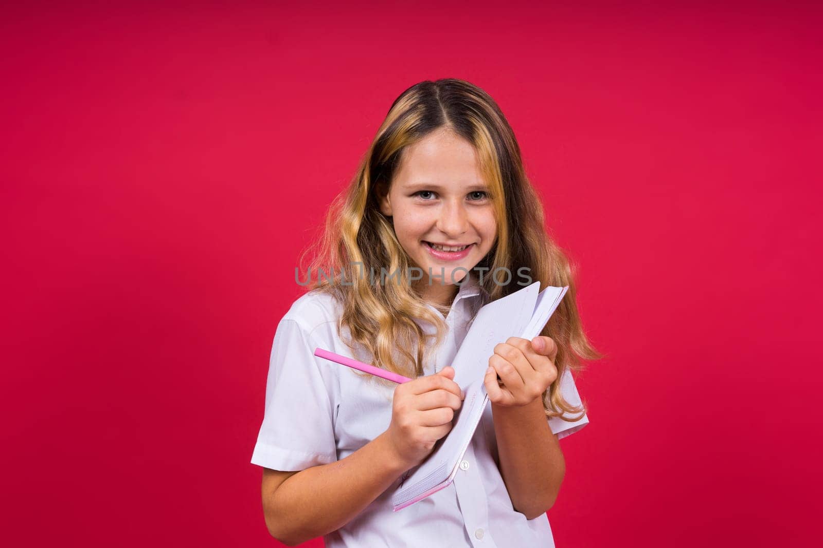 Child making notes. Kids dreams.Isolated on a red background. Education, Kid back to school.