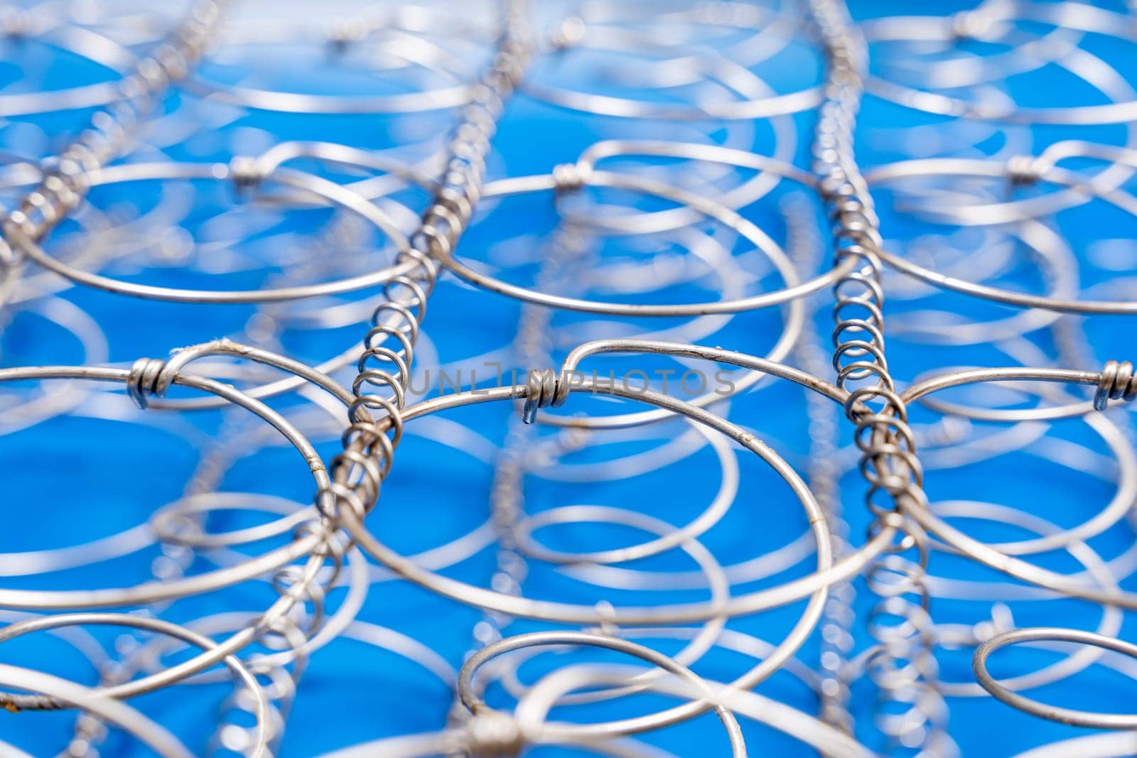 Abstract background The internal structure of a spring mattress. close-up of an old spring mattress on a blue background. Spring block. Sofa and bed. defocusing