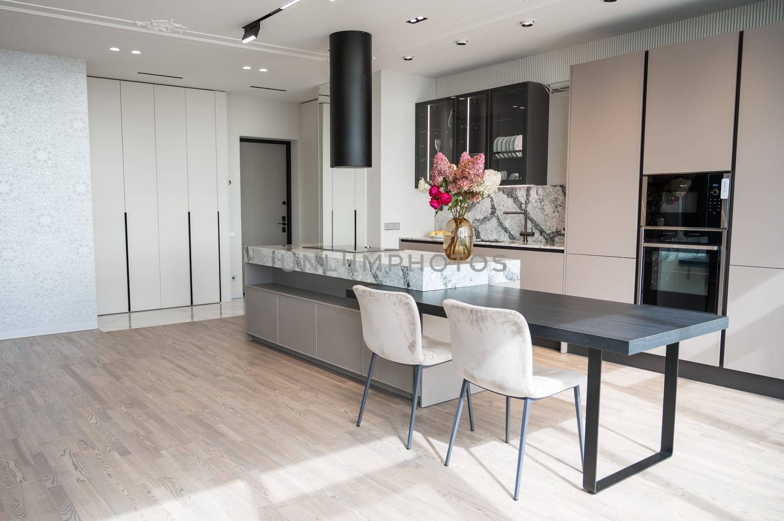 Kitchen in new luxury home with granite quartz table with bouquet of flowers
