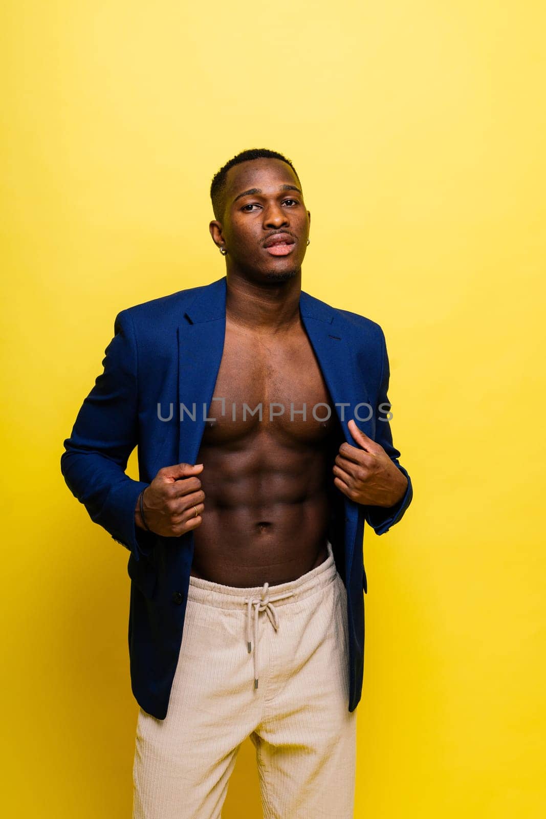 African black man model in a blue suit topless, studio background