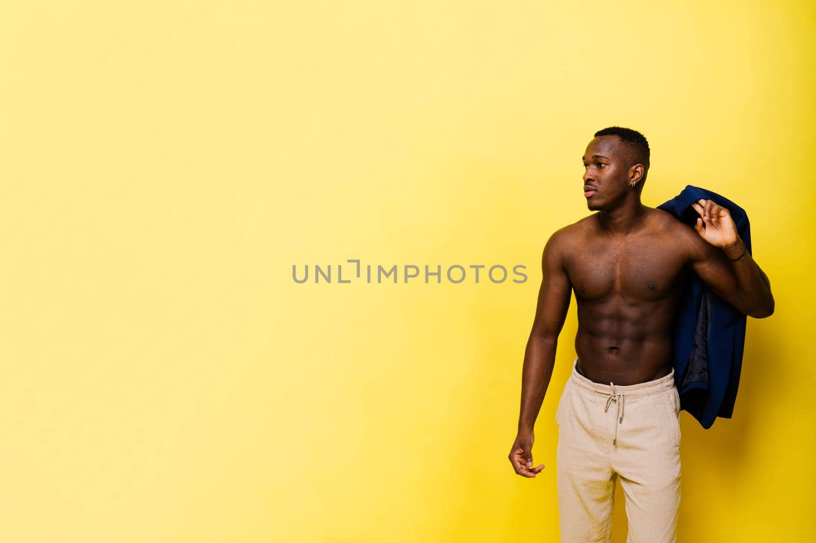 African black man model in a blue suit topless, studio background