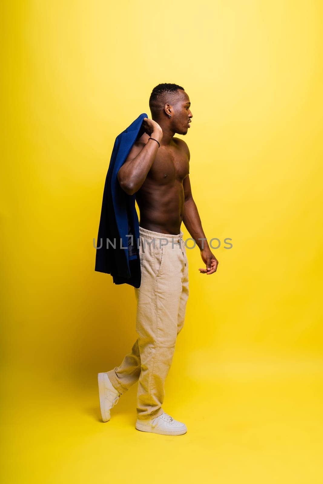 African black man model in a blue suit topless, studio background