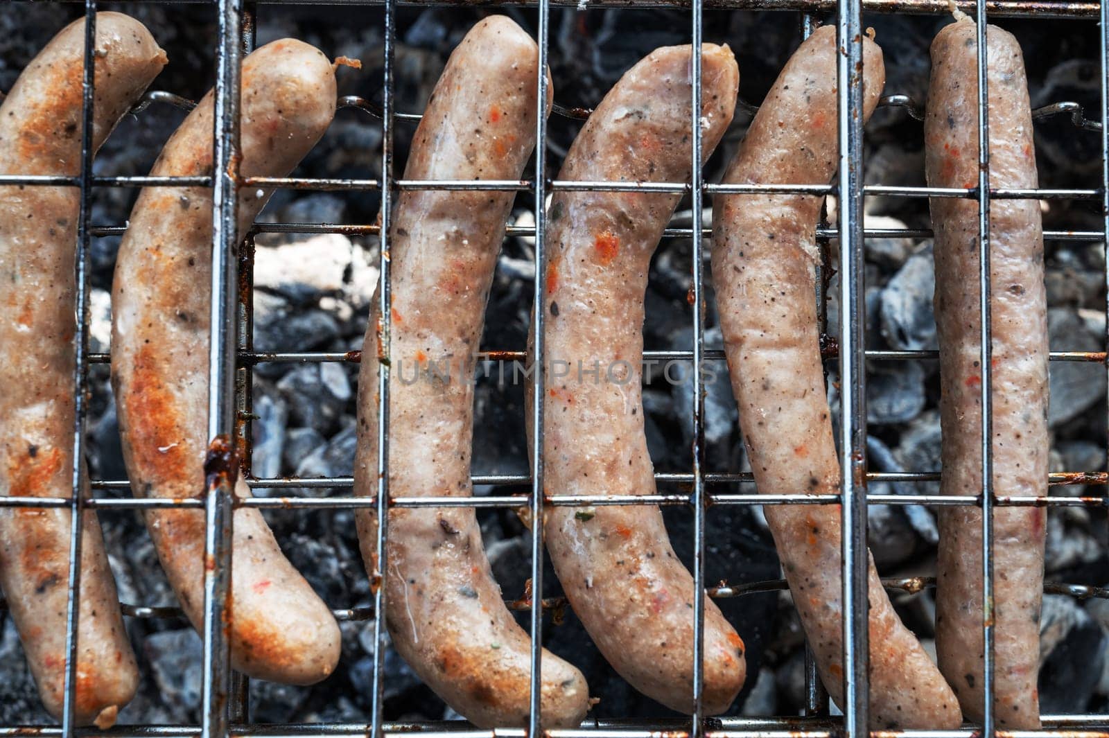 Grilling sausages on the steel grid
