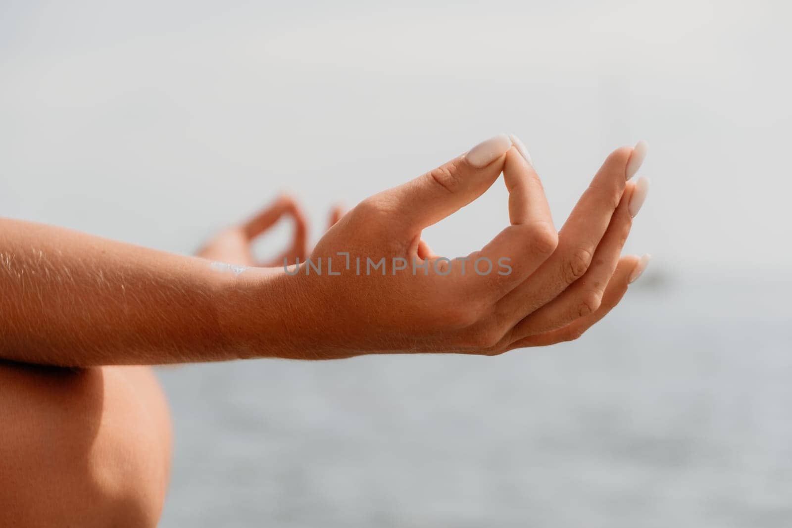 Woman sea yoga. Back view of free calm happy satisfied woman with long hair standing on top rock with yoga position against of sky by the sea. Healthy lifestyle outdoors in nature, fitness concept.