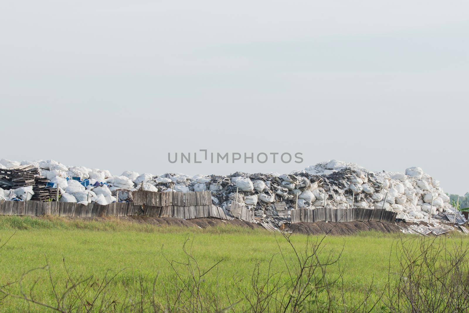 Garbage piles outdoors on a recycle site. by Kumma