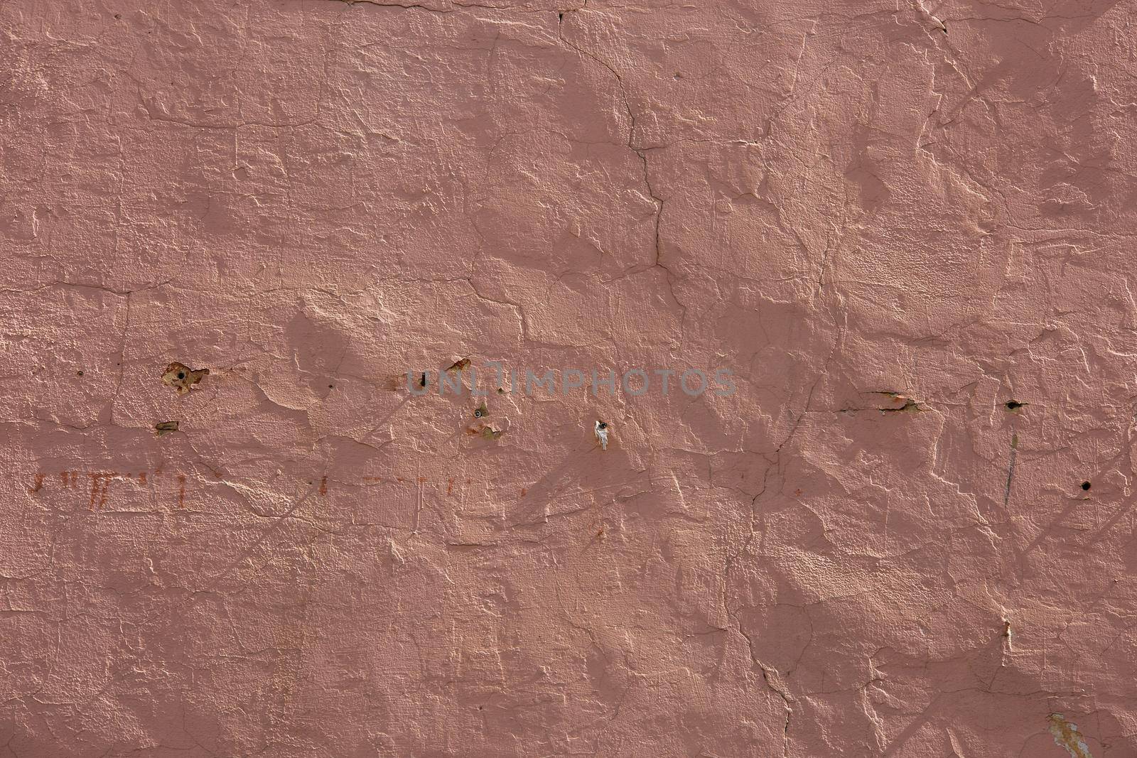 shabby dry pink plaster under direct sunlight texture and full frame background