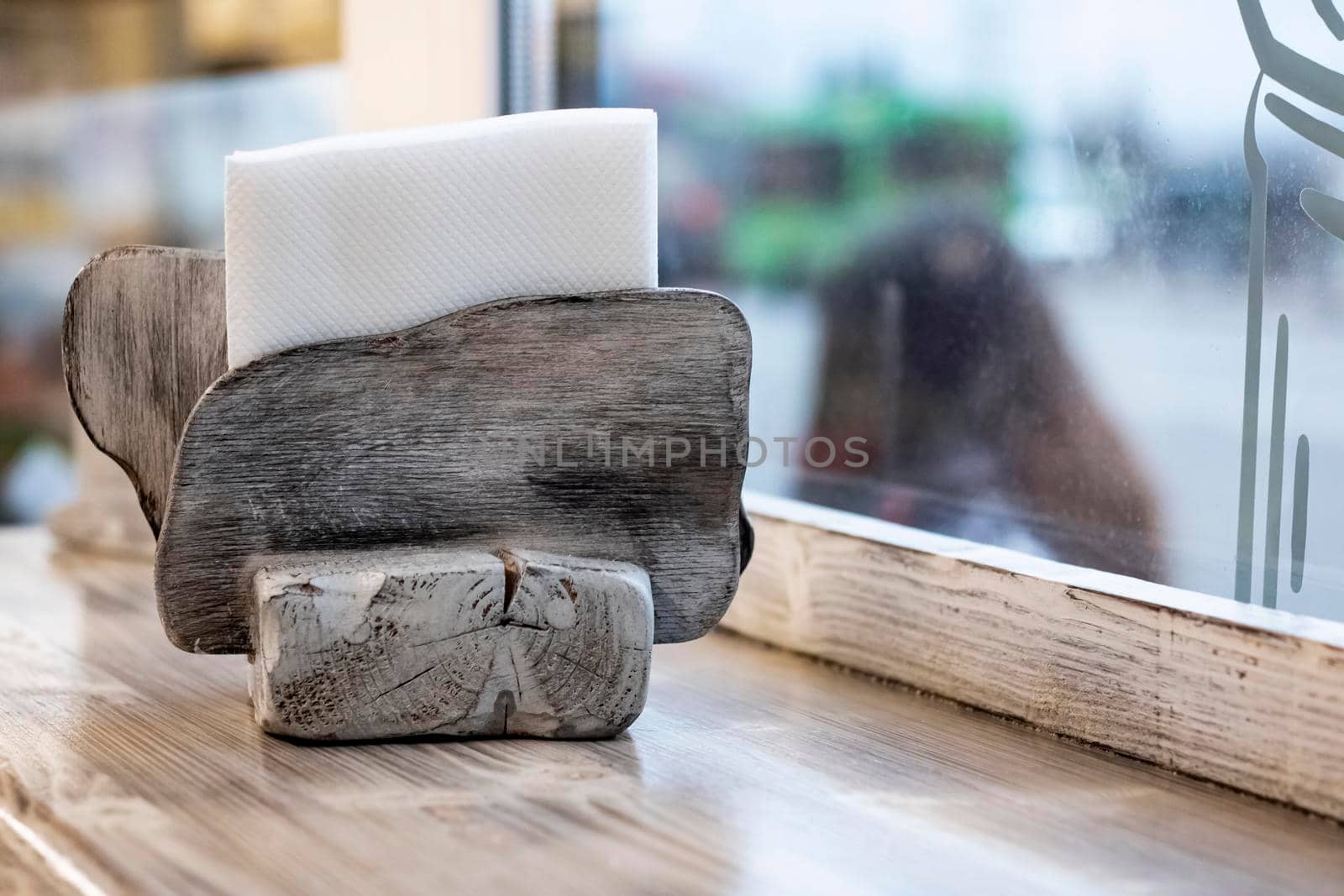 Wooden napkin holder on a wooden table close up