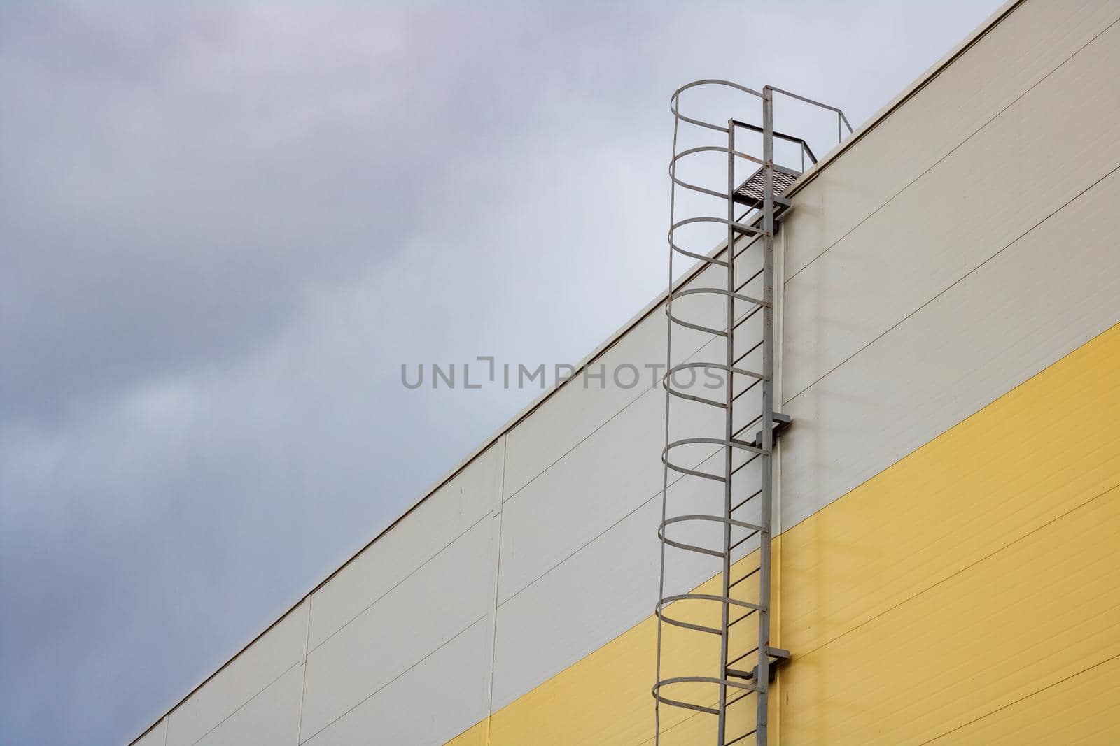 Ladder to the roof of a tall building on a dark sky background, copy space