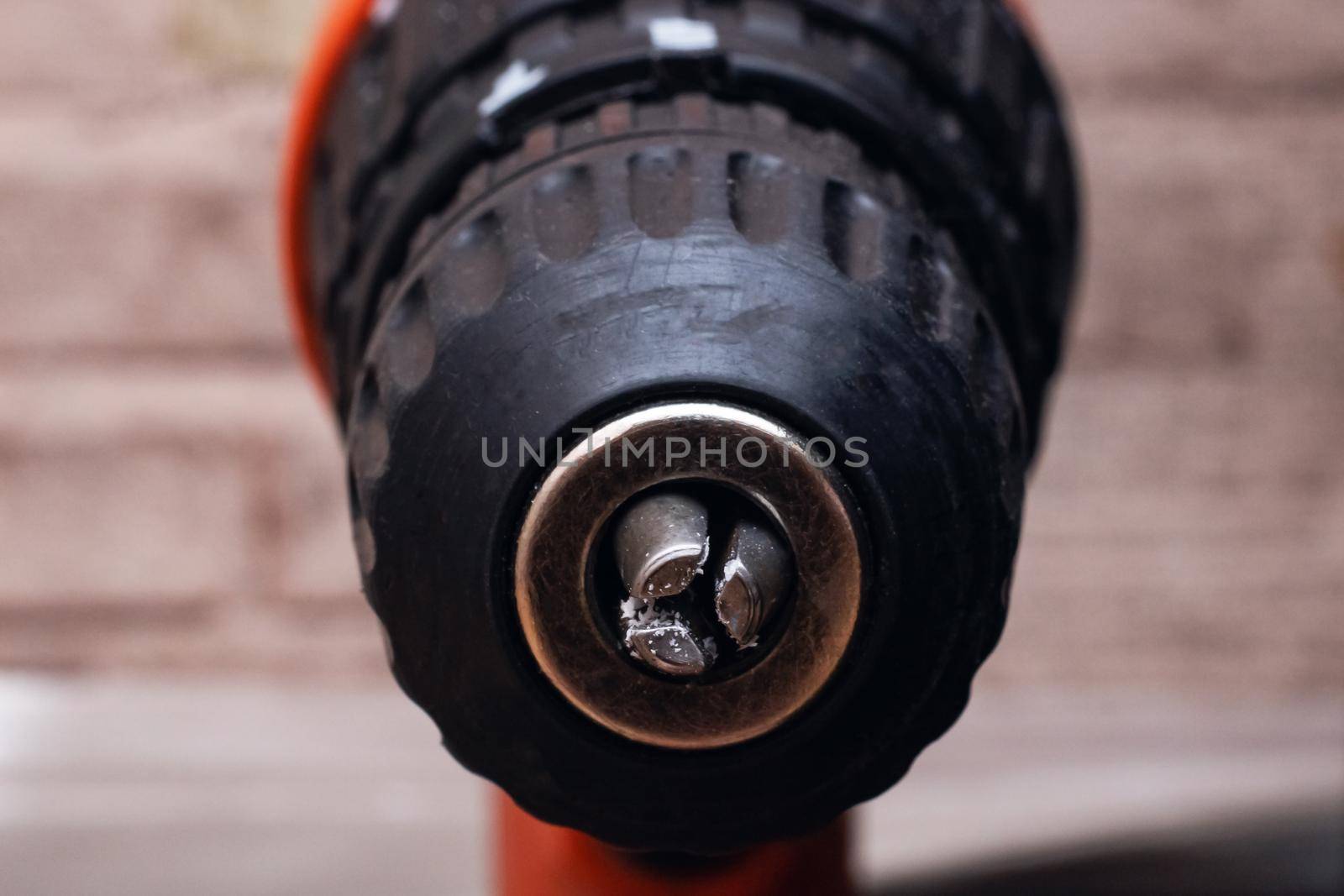 Drill close up on a wooden background with plastic chips