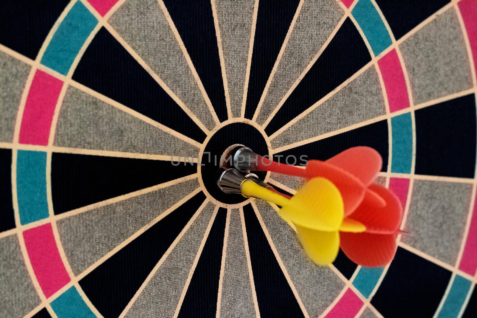 Darts board with darts in the center close up, copy space