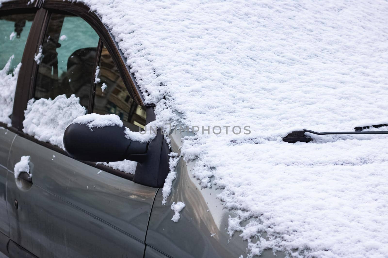 The first snow on a car windshield close up
