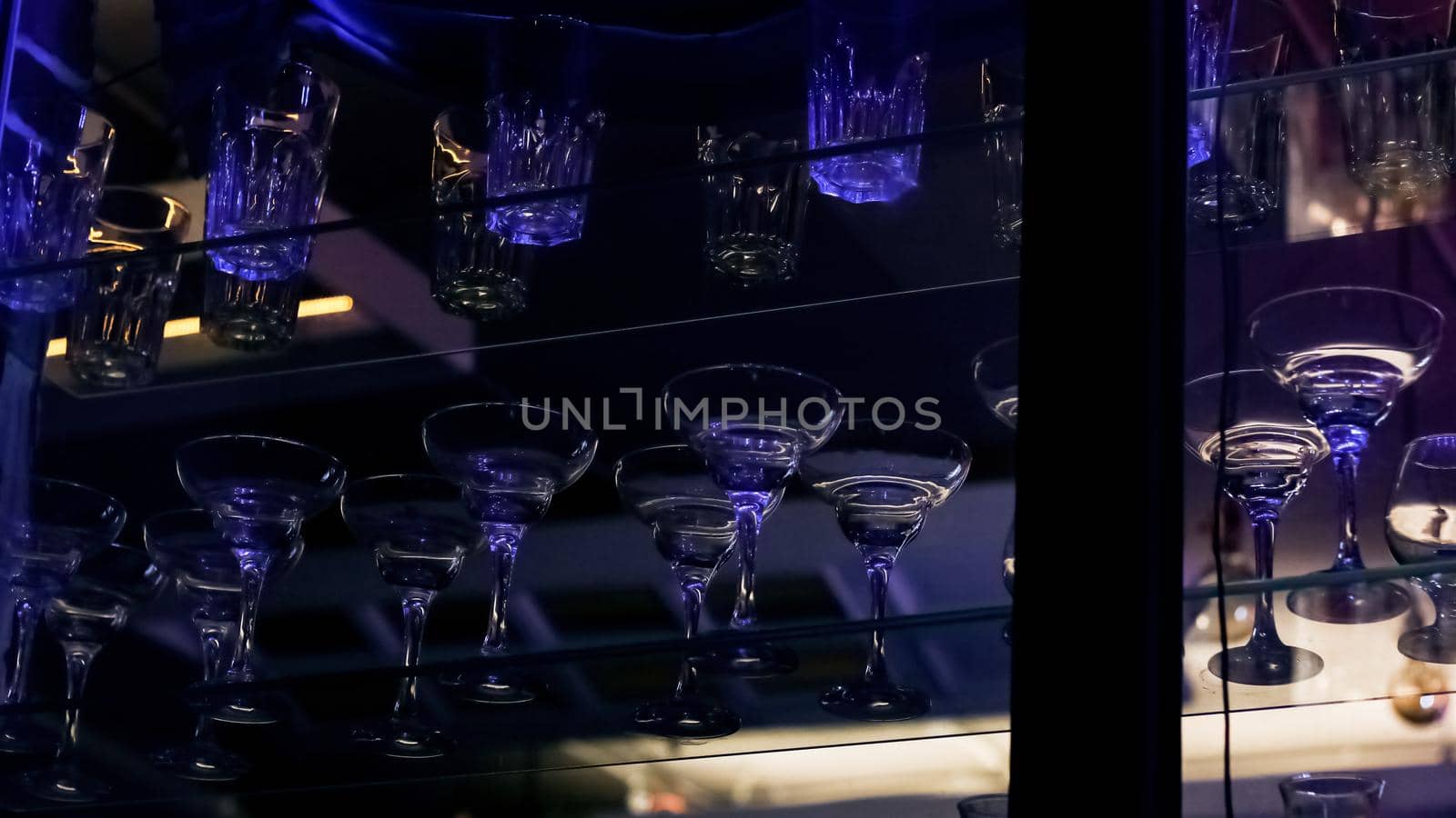 Glass goblets on a shelf in a bar lose up