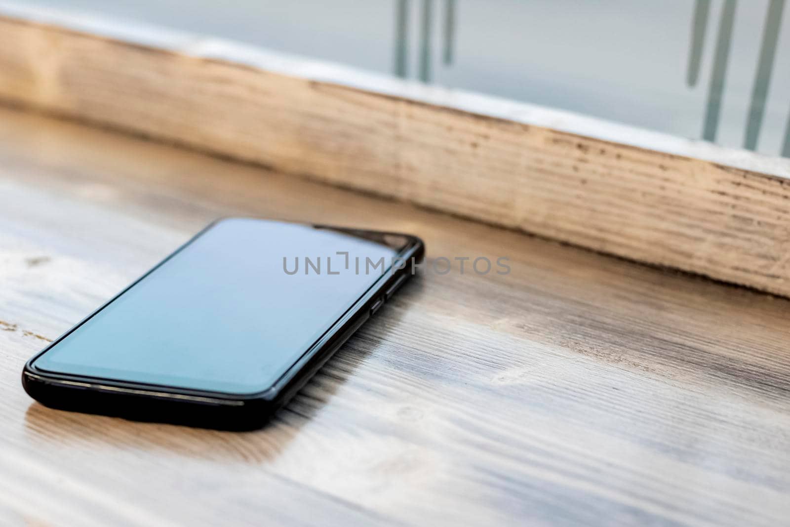 Mobile phone on a wooden table close up, copy space