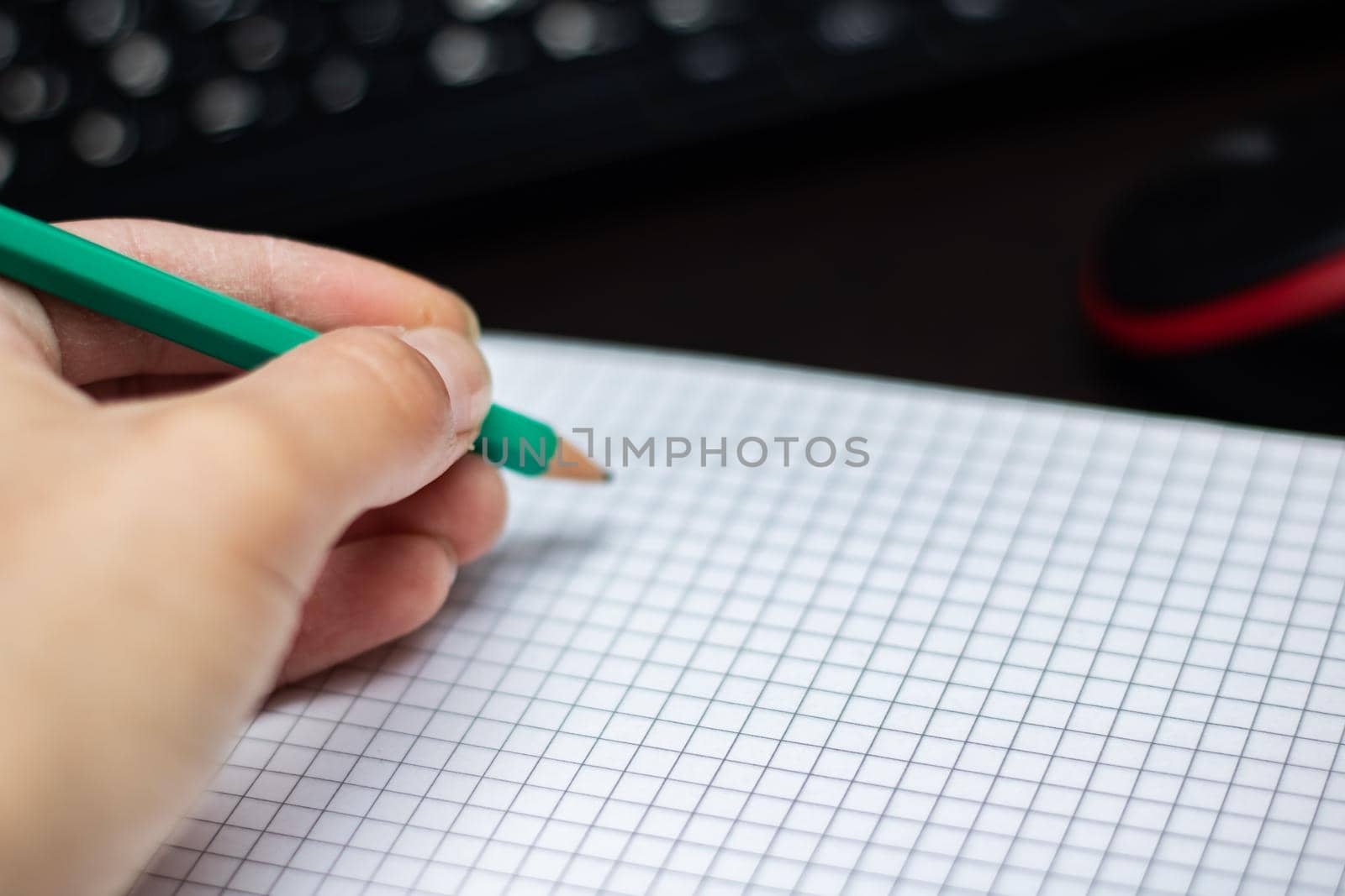 Green pencil in the left hand and a sheet of paper