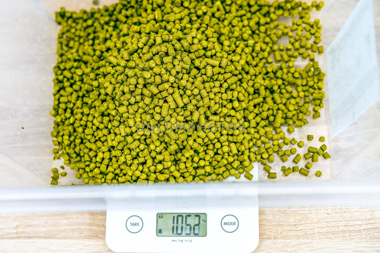weighing granules from hops in the brewery during the production of beer.