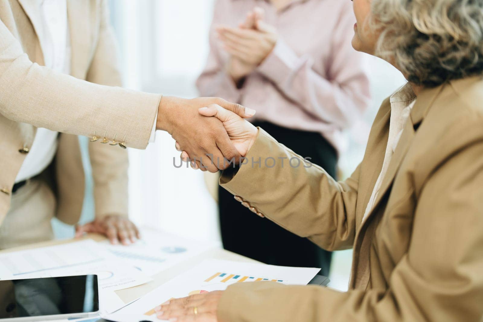 Asian entrepreneurs handshakes to congratulate the agreement between the two companies to enhance investment and financial strength. deal concept by Manastrong