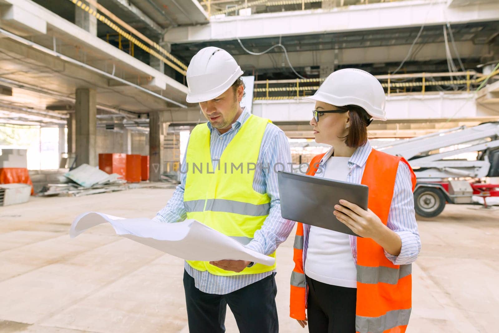 Industrial portrait of male and female engineers in construction of commercial administrative building