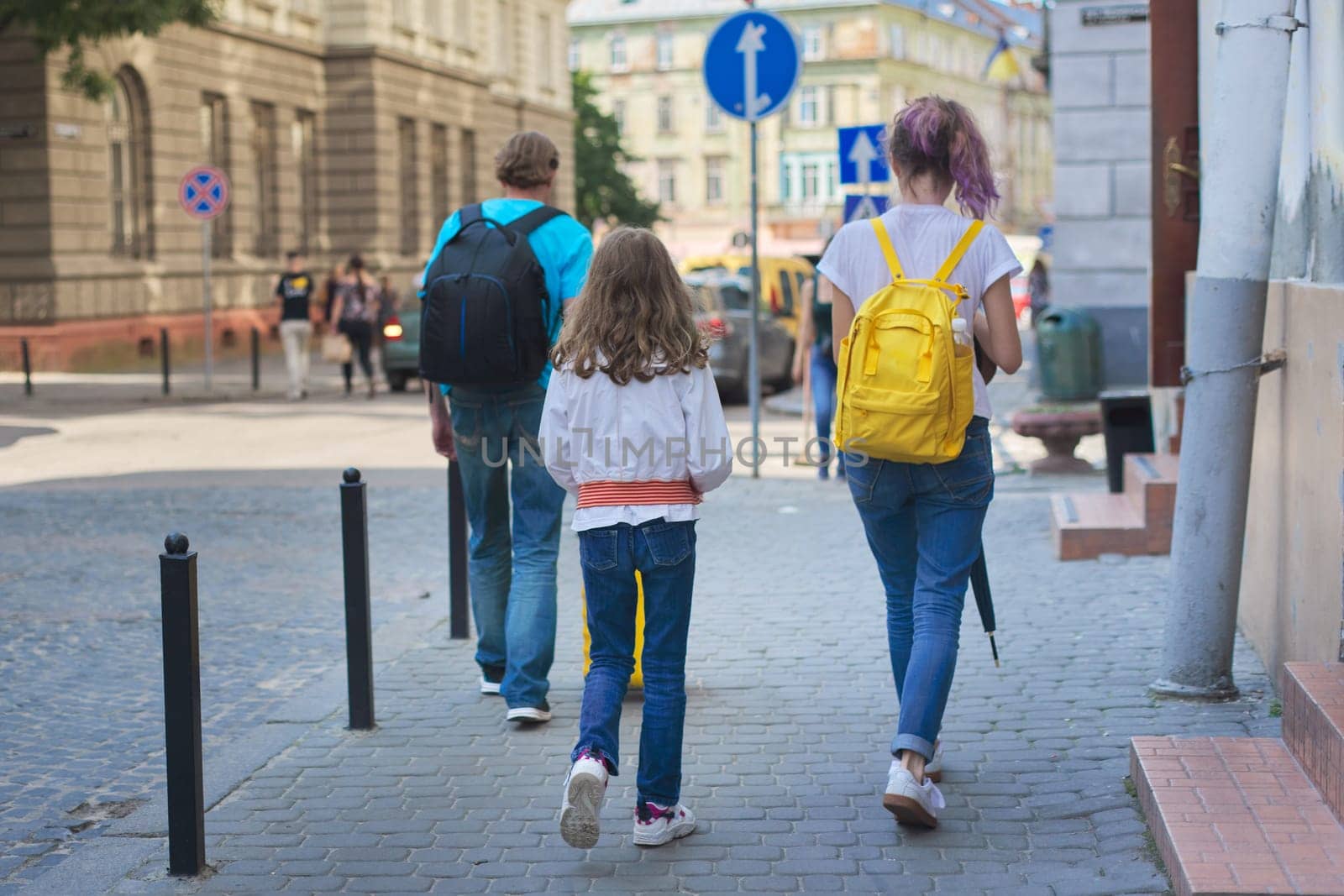 Children two girls daughters and father, tourists walking with backpacks and suitcase by VH-studio