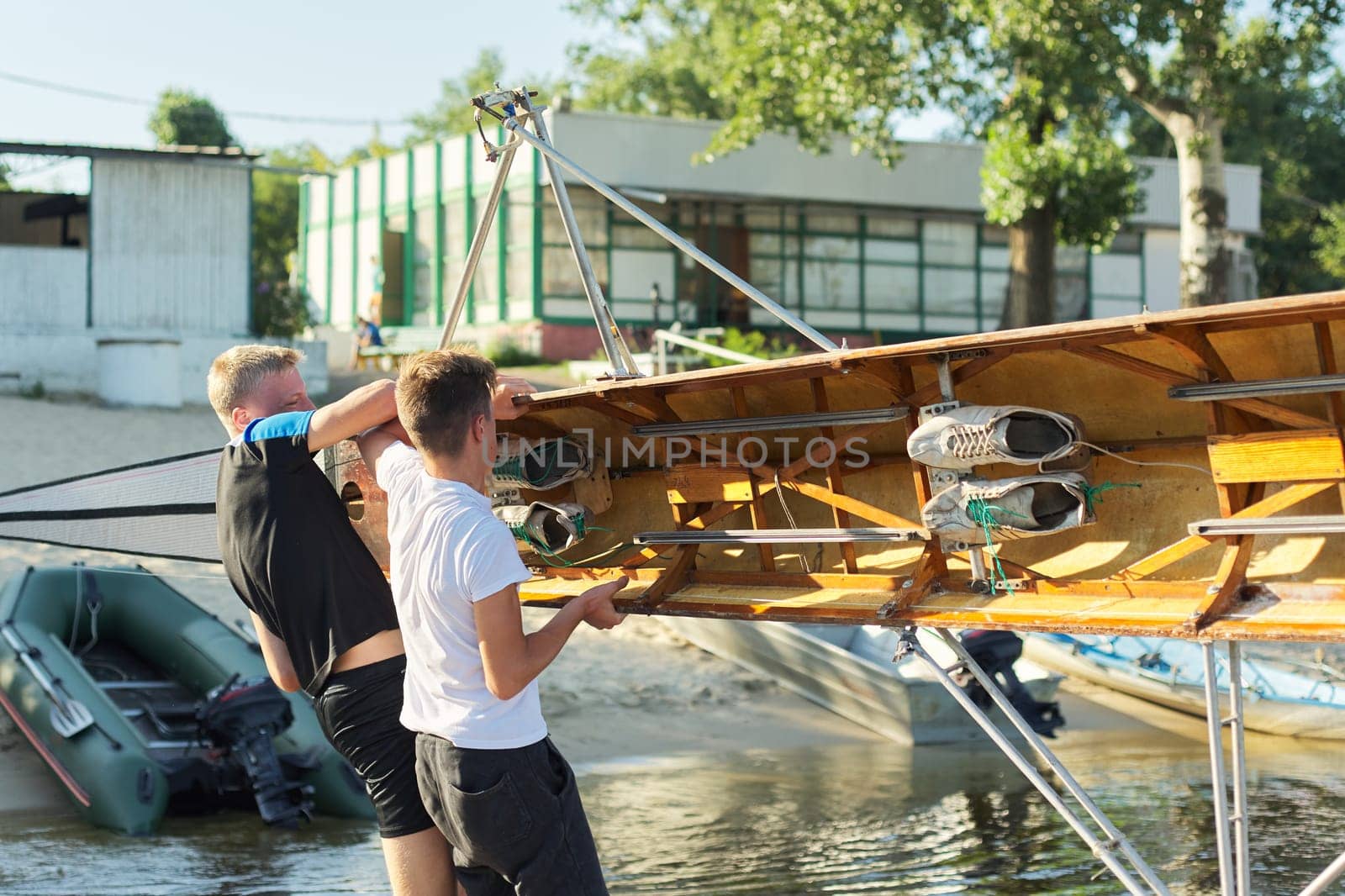 Team of two teenage boys kayaking on river. Active youth lifestyle, water sports, kayak, canoe