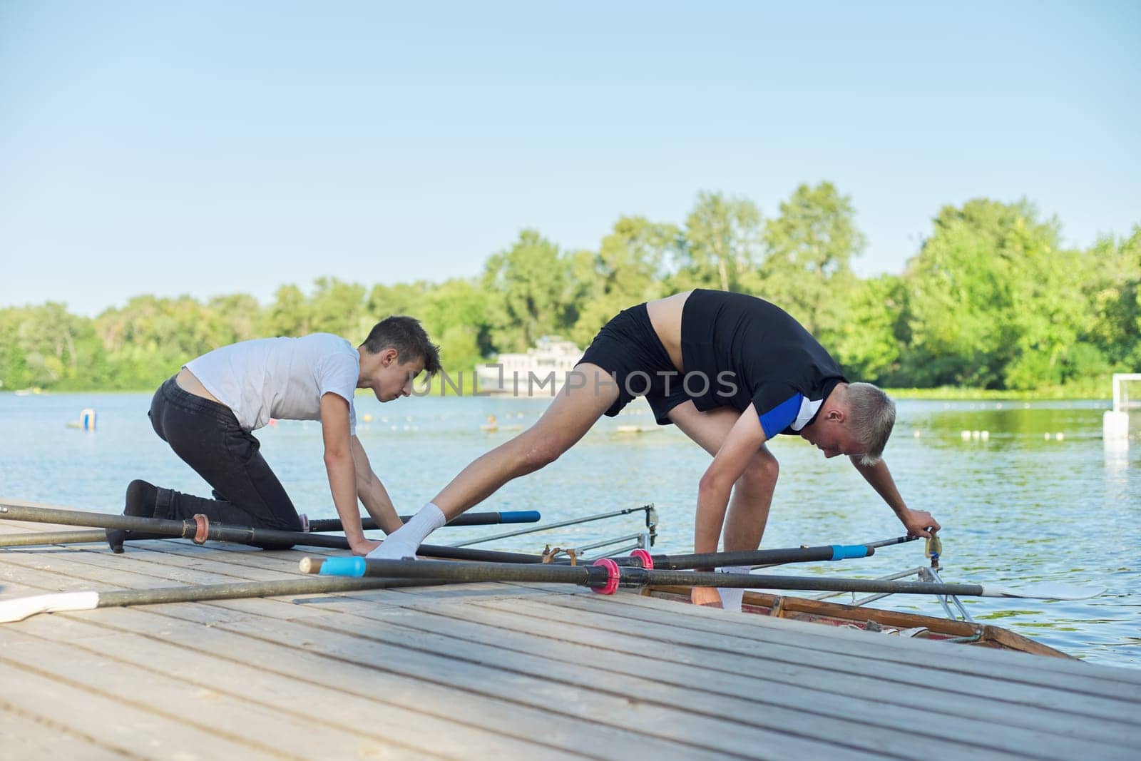 Team of two teenage boys kayaking on river. Active youth lifestyle, water sports, kayak, canoe