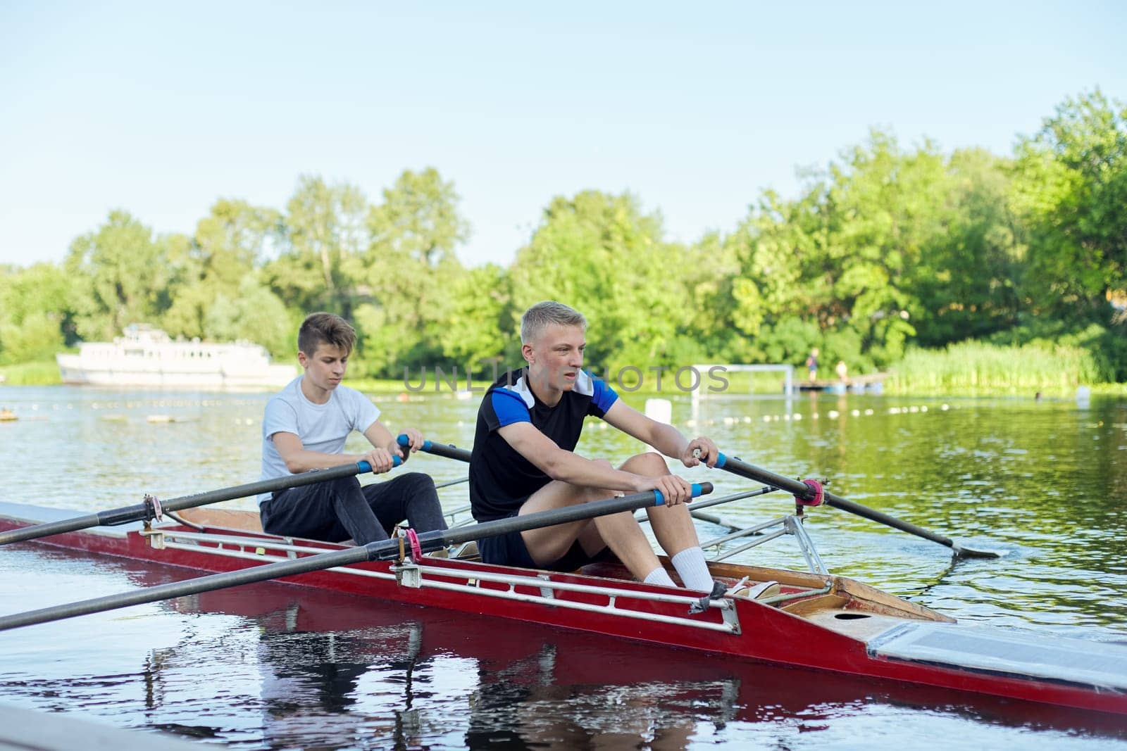 Team of two teenage boys kayaking on river. Active youth lifestyle, water sports, kayak, canoe