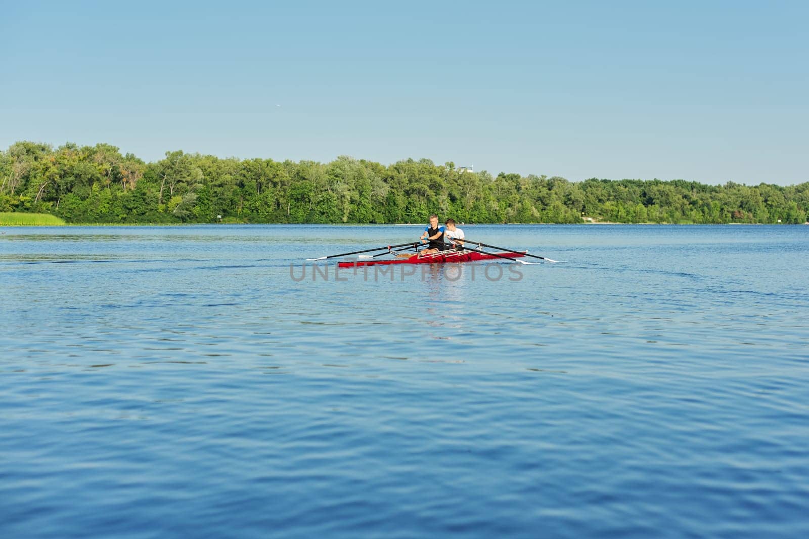 Team of two teenage boys kayaking on river. Active youth lifestyle, water sports, kayak, canoe