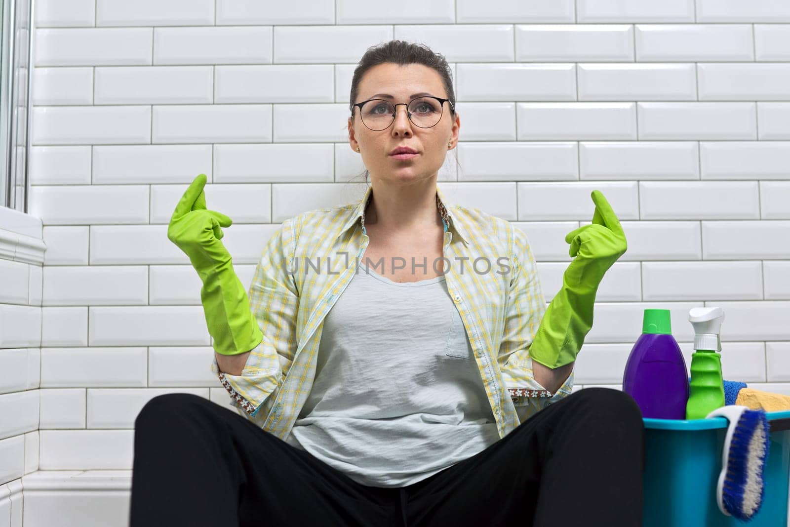 Tired woman sitting in bathroom on floor and meditating. by VH-studio