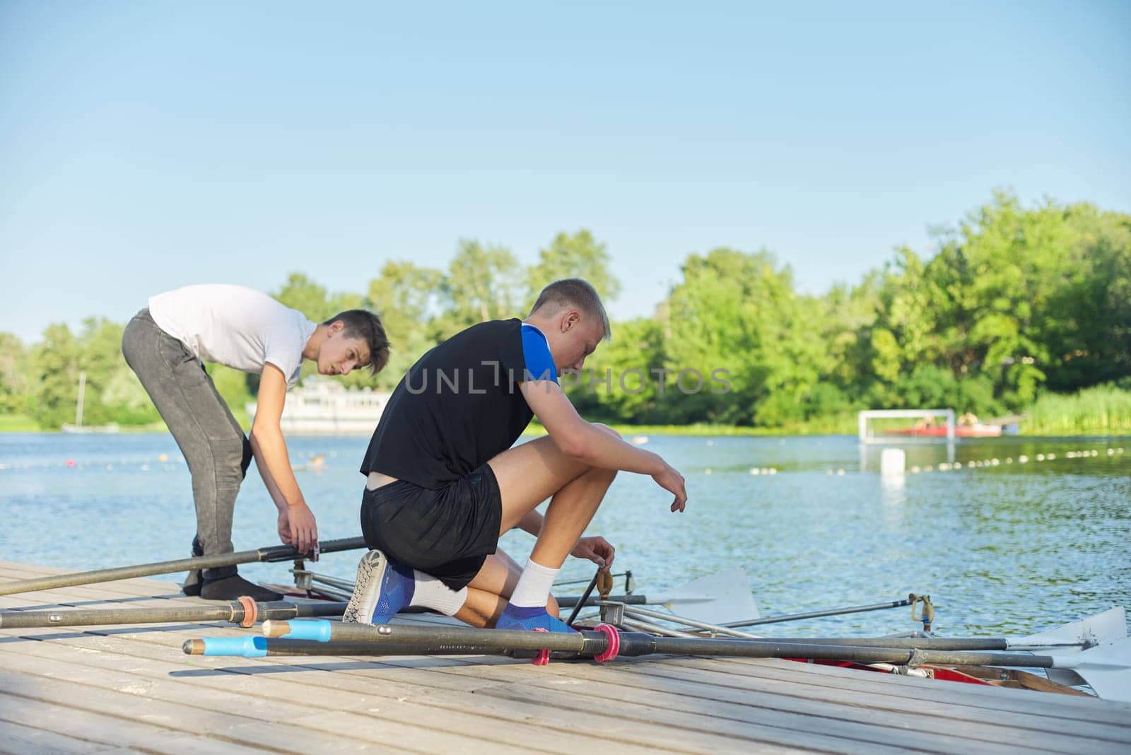 Team of two teenage boys kayaking on river. Active youth lifestyle, water sports, kayak, canoe