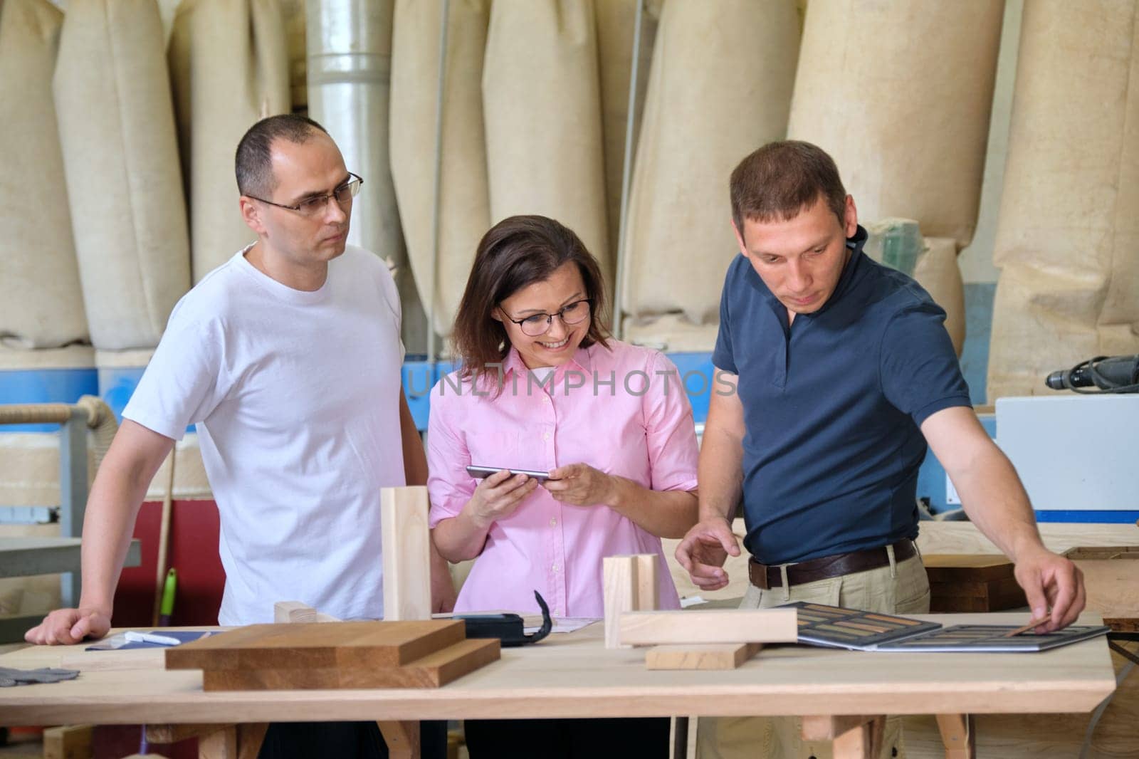 Team of woodworking workshop workers are discussing by VH-studio