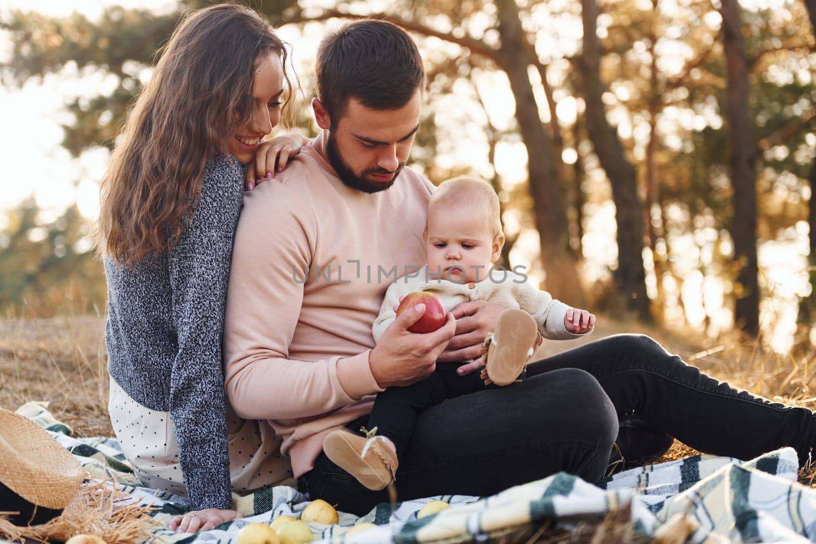 Haves picnic. Happy family of mother, family and little baby rests outdoors. Beautiful sunny autumn nature.