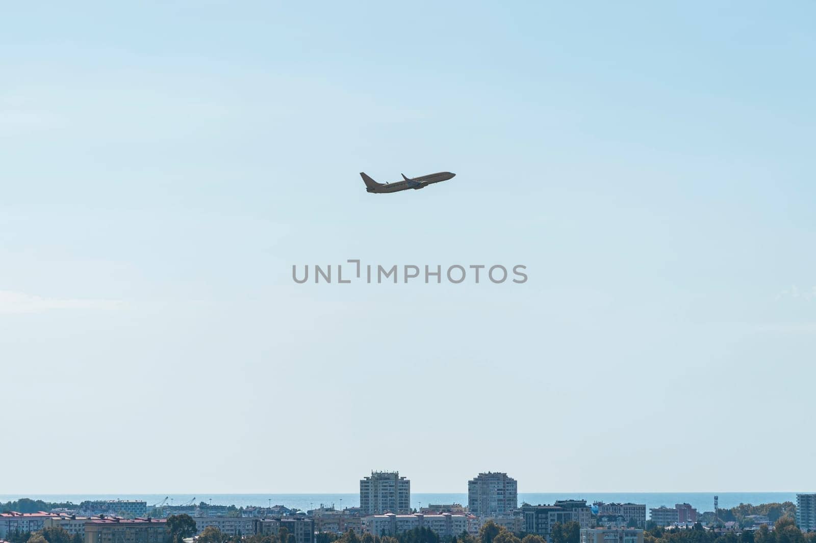 the plane is flying against a background of blue sky and sun. photo