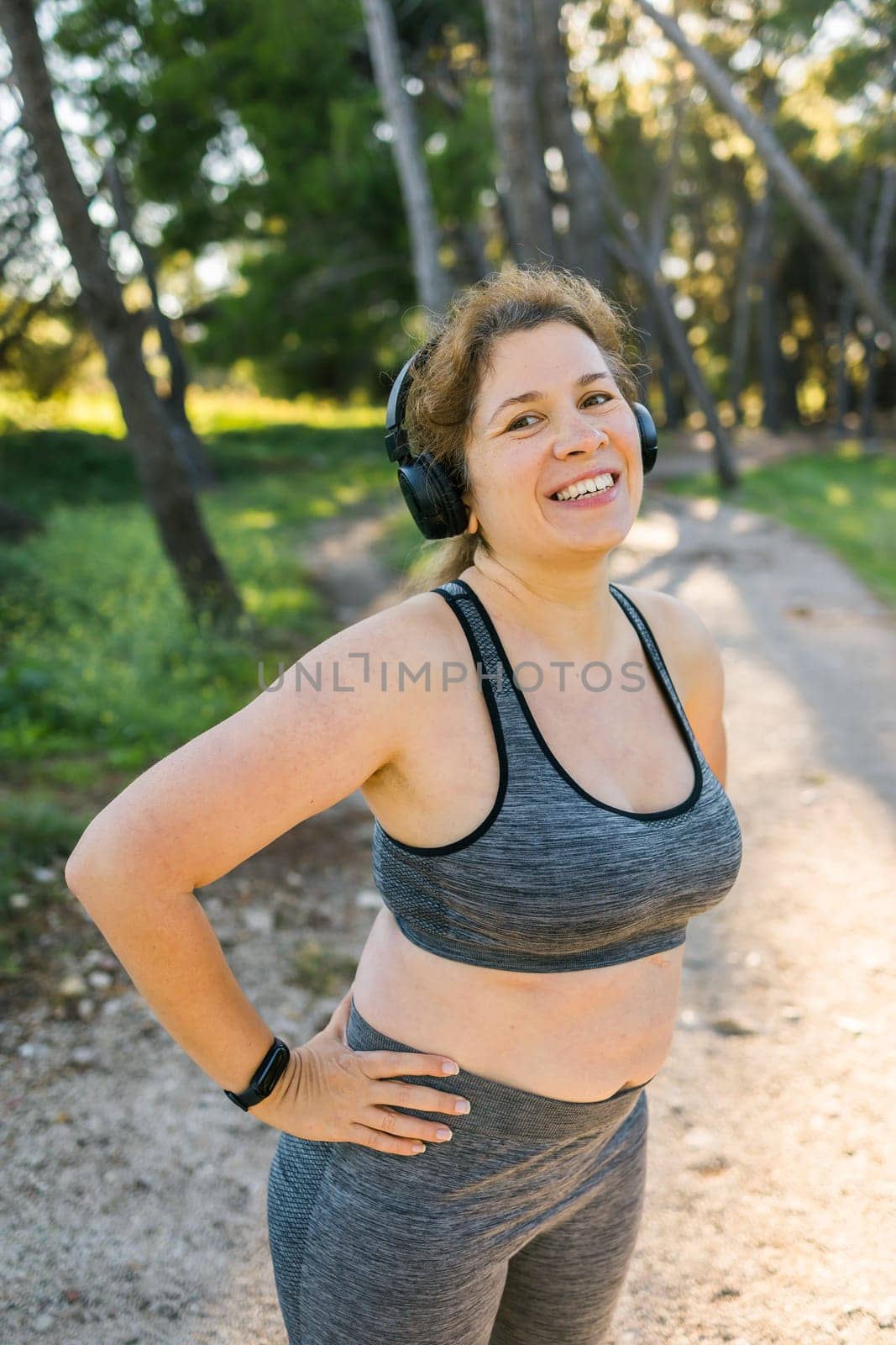 Fat woman and sports. Girl doing exercise for weight loss in the fresh air and laughing in camera after training by Satura86