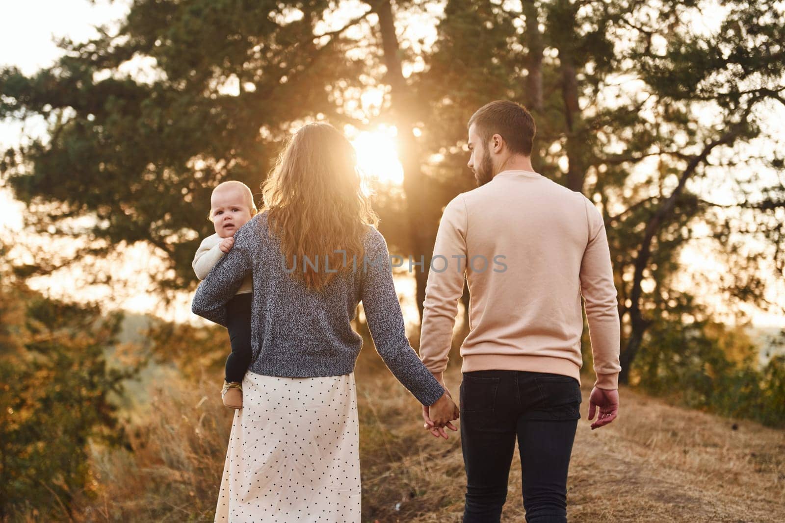 Unity of the people. Happy family of mother, family and little baby rests outdoors. Beautiful sunny autumn nature.