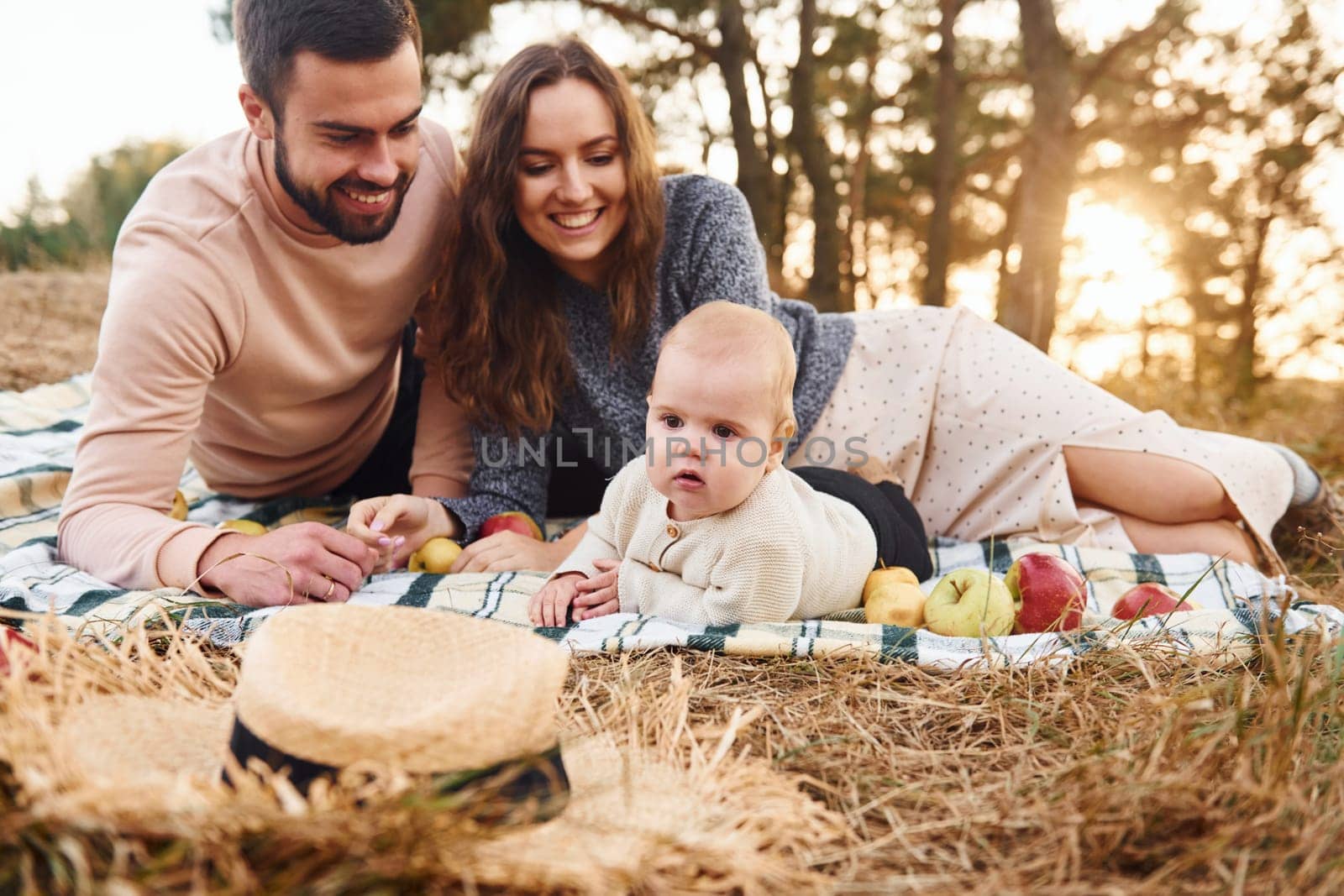 Haves picnic. Happy family of mother, family and little baby rests outdoors. Beautiful sunny autumn nature.